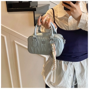 Detail of light blue quilted leather boston bag with High Ydn logo and tassel charm