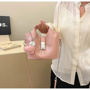 Détail du sac seau rose clair en cuir ciré avec boucle argentée et pendentif en cœur