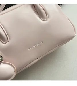 Close-up of pink soft leather bowling bag with Rioa & Luxury embossed branding