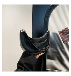 Détail du sac hobo minimaliste noir en cuir ciré avec anneaux métalliques élégants