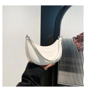Gros plan d'un sac demi-lune blanc avec l'inscription gaufrée FASHION & BAG