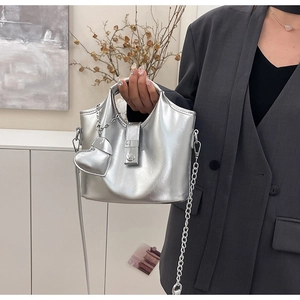 Détails du sac seau argenté en cuir huilé avec breloque cœur et bandoulière chaîne