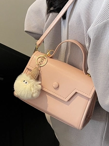 Piccola borsa quadrata rosa chiaro minimalista con manico e ciondolo mostro di peluche