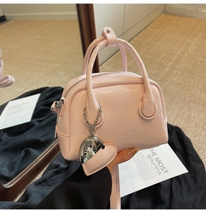 Detail of pink oil wax leather bowling bag with heart charm and embossed letters