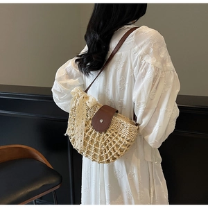 Detail einer hohlen Strohtasche mit Spitzenschleife und Lederriemen für Damen