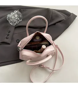Spacious interior of light pink Boston bag showing phone, wallet, and lipstick