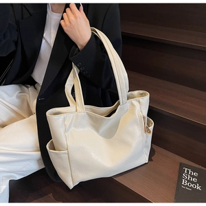 Detail of soft cream tote bag showing spacious side pockets and crinkled leather texture