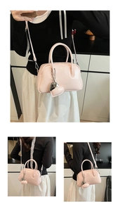 Detailed macro view of pink PU leather Boston bag with chic heart charm and shoulder strap