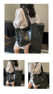 Detail view of large black tote bag with silver magnetic snap pocket and side pouches