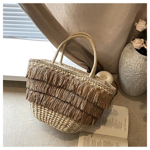 Vue détaillée du sac cabas en paille tressée avec trois couches de franges décoratives