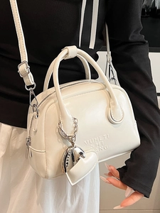 White oil wax leather bowling handbag with heart charm and detachable shoulder strap