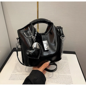 Détail du sac seau noir en cuir ciré avec fermoir argenté et breloque en cœur