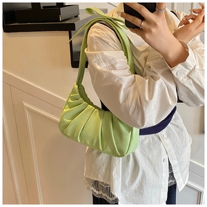Détail du sac nuage plissé vert clair avec un nœud élégant sur la bandoulière