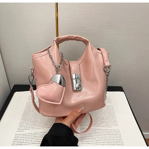Vue détaillée d'un sac seau en cuir ciré rose avec chaîne argentée et charm en cœur
