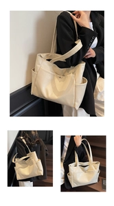 Detail of cream tote bag featuring textured leather, magnetic front pocket and side slots