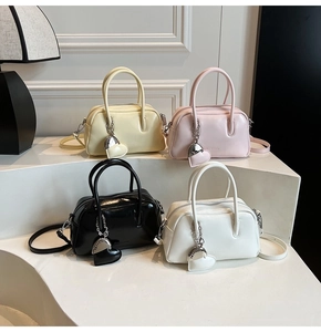 Detail showing soft leather Boston bags in four colors with heart pendants and straps