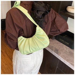 Détail du sac plissé vert clair avec un grand nœud sur la bandoulière large