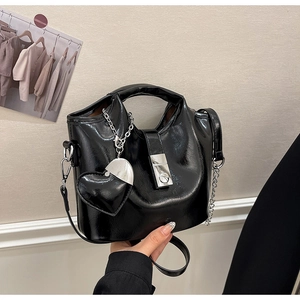 Détail du sac seau en cuir ciré noir avec pendentif en cœur et détails de chaîne argentée