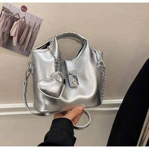 Détail du sac seau argenté métallisé avec breloque coeur et fermoir magnétique