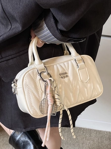 Quilted cream leather handbag with metallic logo and trendy sports charms for women