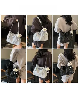 Mannequin portant de grands sacs hobo en gris et noir avec texture douce et bijou de sac