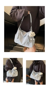 Détail du sac cabas en similicuir bleu clair avec breloque peluche et poches zippées