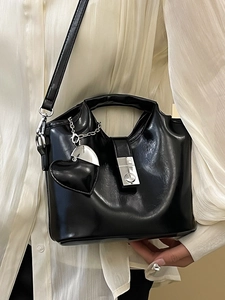 Sac seau minimaliste en cuir ciré noir avec breloque cœur et détails métalliques argentés