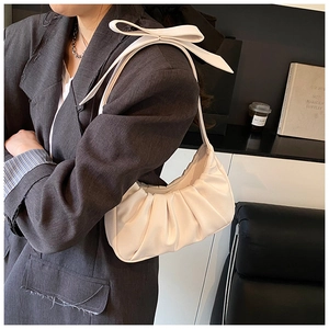 Détail du sac nuage blanc plissé avec texture douce et nœud élégant sur la bandoulière