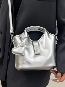 Sac seau en cuir argenté métallisé avec breloque cœur et chaîne sur modèle