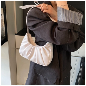 Vue détaillée d'un sac à bandoulière blanc plissé avec un élégant nœud sur la sangle
