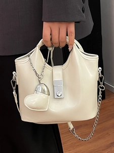 Sac seau minimaliste en cuir blanc crème avec fermoir argenté et breloque cœur