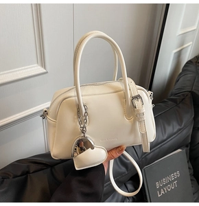 Detail of white PU leather bowling bag with heart charm and brand lettering