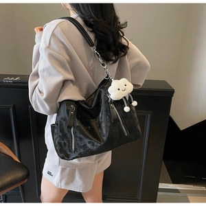Détail du sac hobo noir rétro avec fermeture éclair argentée et breloque nuage