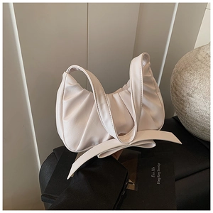 Gros plan détaillé du sac nuage plissé crème avec nœud élégant et texture en cuir
