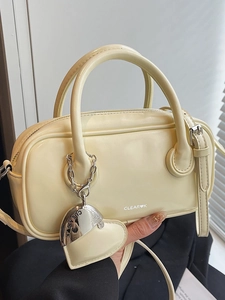Sac polochon chic jaune crème avec pendentif cœur argenté et design minimaliste femme