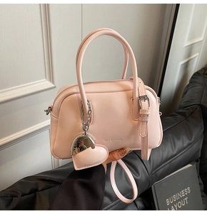 Close-up of pink leather Boston bag with Rica Luxury logo and heart charm detail