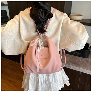 Close-up of pink litchi grain tote bag with pearl and lace pendant details
