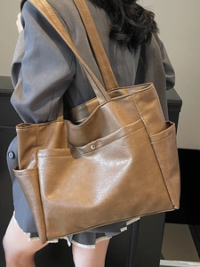 Minimalist coffee brown large capacity soft leather tote bag for women shown on shoulder