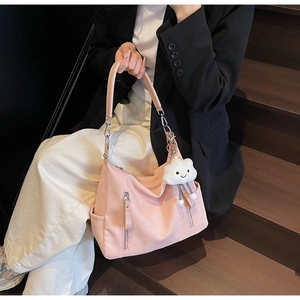 Détail du grand sac hobo rose en similicuir avec charme nuage porté par un mannequin