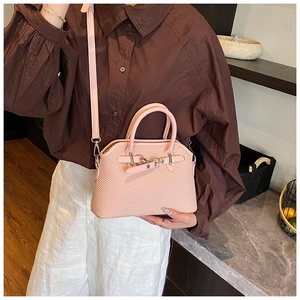 Détail du sac en similicuir rose texturé avec boucle en métal argenté et bandoulière