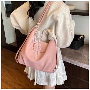Detail of pink pebbled leather hobo tote bag with lace pearl charm accessory