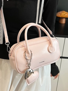Sac Boston en cuir verni rose avec logo CLEAR-K et charm coeur dans un cadre moderne