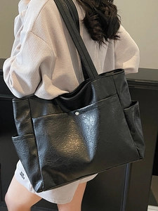 Minimalist black soft leather tote bag with large capacity and side pocket detail