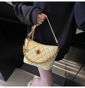 Detailed view of the yellow quilted bucket bag with gold chain and metal twist lock