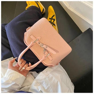 Gros plan du sac rose tissé avec poignée en cuir et détails de serrure en métal argenté