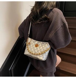 Detail of silver quilted bucket bag with gold chain strap and metal swivel lock