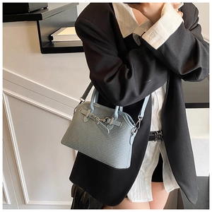 Détail du sac bandoulière bleu clair en cuir texturé avec fermoir argenté élégant