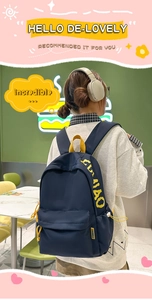 Detail of durable navy nylon backpack with contrast yellow handles and branding label