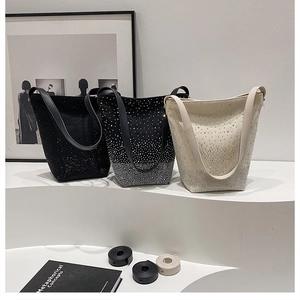 Detailed view of rhinestone bucket bags in black, grey, and off-white with leather straps