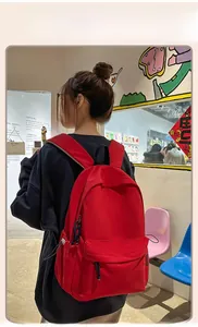Detailed view of the red casual backpack with wide cushioned shoulder straps on a model